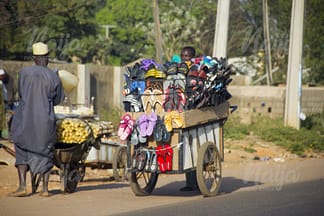 LOCAL TRADERS SELLING THEIR PRODUCTS ON THE ROAD USING WHEELBARROWS