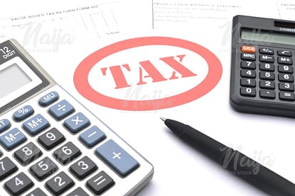 TAX PRINTED ON A WHITE PAPER WITH TWO CALCULATORS AND A PEN
