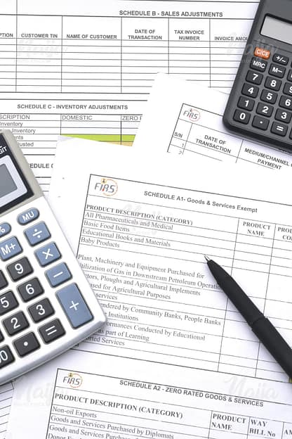 TAX FORM, BLACK PEN AND TWO CALCULATORS