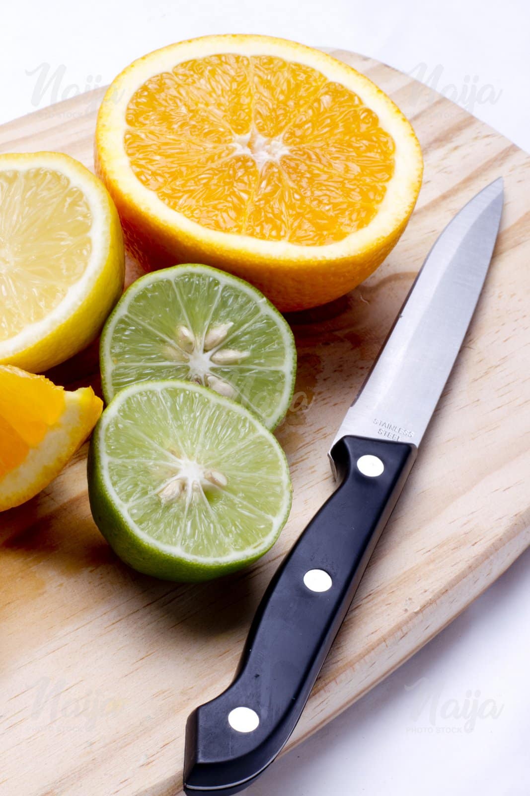 CITRUS FRUITS ON A WOODEN BOARD WITH A KNIFE