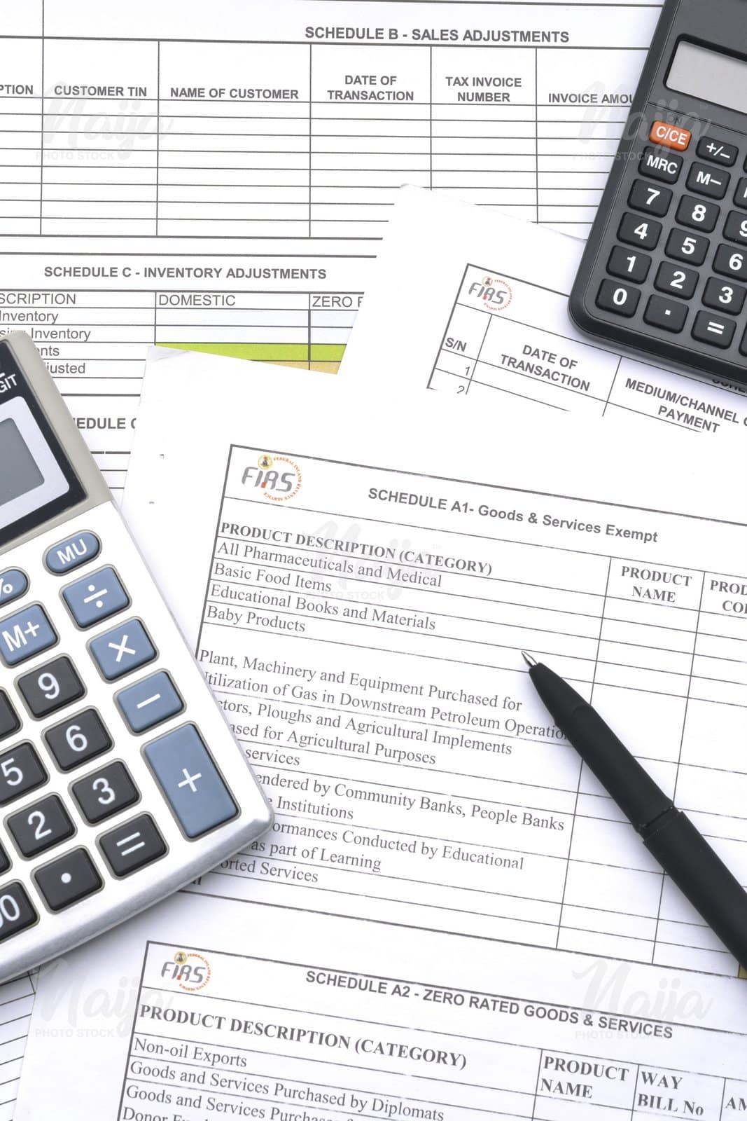 TAX FORM, BLACK PEN AND TWO CALCULATORS