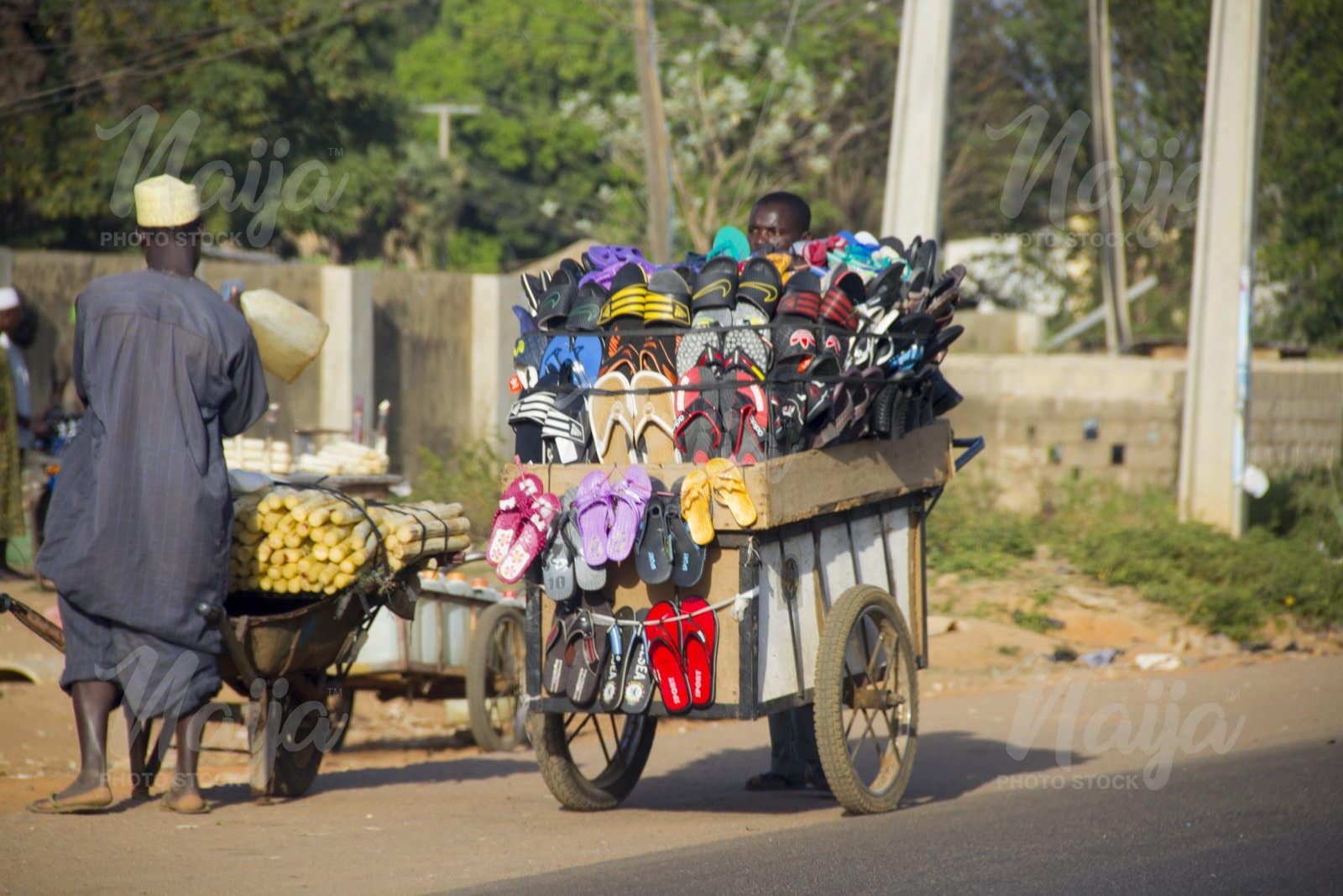LOCAL TRADERS SELLING THEIR PRODUCTS ON THE ROAD USING WHEELBARROWS